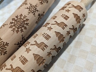 wooden rolling pins with Christmas and New Year patterns for making cookies for the holiday
