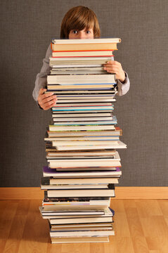 Boy Behind Stack of Books