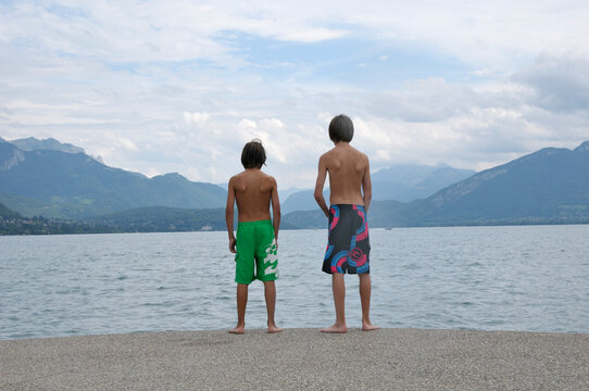 Back View of Boys Standing on Shore of Lake, Annecy, Alps, France