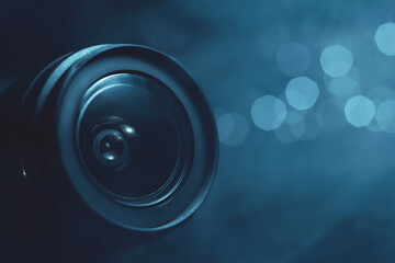 Camera lens in smoke close-up, lights out of focus on the background, cyan color