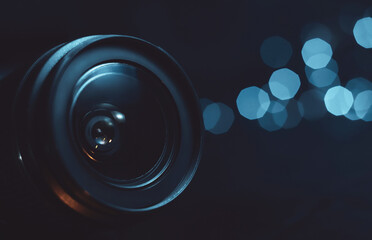 Camera lens close-up, lights out of focus on the background, cyan color