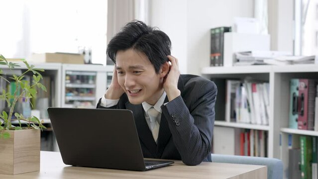 オフィスで頭を抱えるビジネスマン