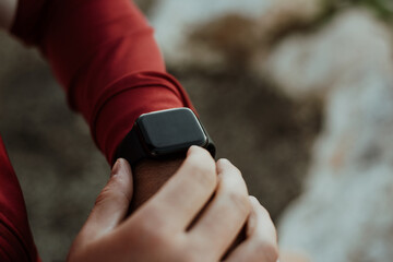 Man Using A Digital Smartwatch During Workout. Closeup View Of Man's Hands Checking An App In Smartwatch. Close-up Of A Clock That Shows Steps, Kilometers And bpm.