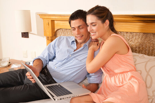 Couple using Laptop in Hotel Room, Reef Playacar Resort and Spa, Playa del Carmen, Mexico