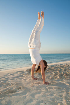 Woman doing Handstand on Beach, Reef Playacar Resort and Spa, Playa del Carmen, Mexico