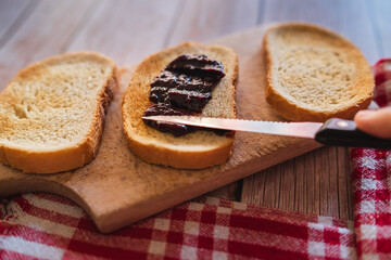 Top view of jam spreading on piece of bread on the table breakfast during the day or in the morning