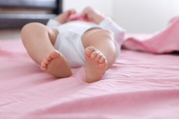 Little baby lying on bed indoors, closeup