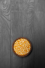 ceramic plate with corn kernels on the black wooden table
