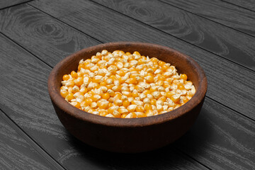 ceramic plate with corn kernels on the black wooden table