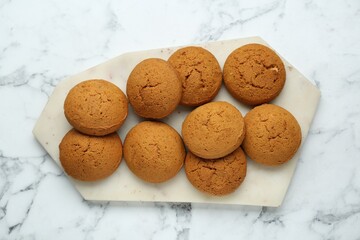 Tray with tasty oatmeal cookies on white marble table, top view