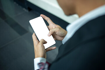 Business man  in a black suit watching mobile phones with white screens. Asian man pressing the phone screen with clipping path. Blank screen phone.