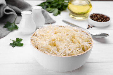 Bowl of tasty sauerkraut on white wooden table