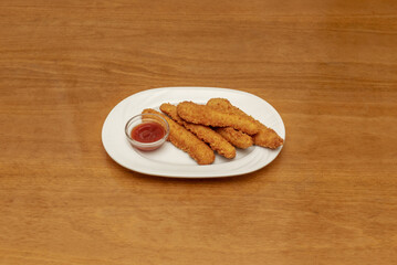 A serving of crispy chicken on a white porcelain tray with a glass bowl of sauce