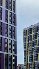 Naklejka premium The facade of the building in purple,geometric patterns from windows and balconies, the colored wall of a modern multi-storey residential building, the abstract texture of the facade of the house