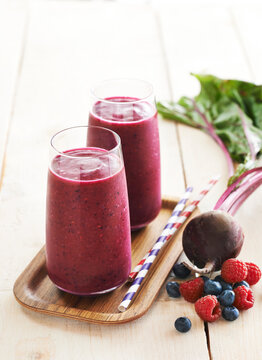 Berry and beet smoothies on tray, studio shot