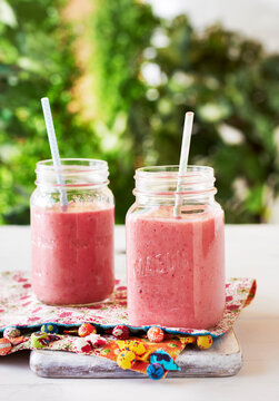 Berry Smoothies in mason jars with straws, outdoor studio shot