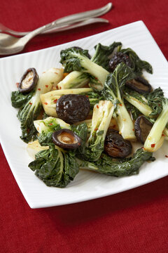 Bok choy with mushrooms on red background