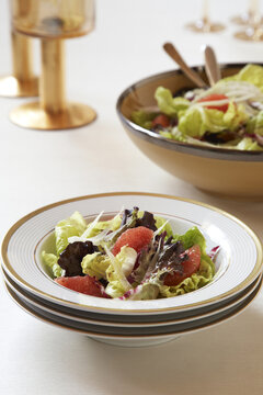 Salad with grapefruit in white and gold bowl