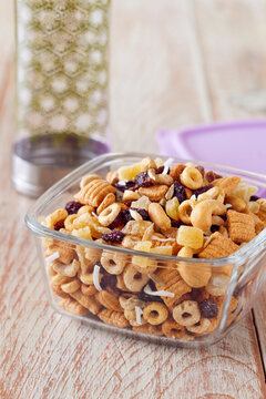 Healthy snack mix in a portable glass storage container with a water bottle