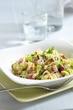Bowl of rotini with bacon, purple onions and cabbage