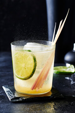 Lemongrass cocktail with lime on a black background