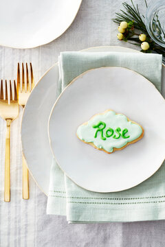 Sugar cookie place card with name in icing on a dinner plate in a festive place setting