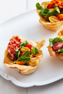 Bacon And Tomato Phyllo Cups On A White Platter