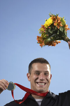Man Holding Medal and Bouquet