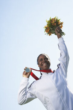 Woman Holding Medal and Bouquet