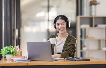 Young adult happy smiling Hispanic Asian girl student wearing headphones talking on online chat meeting using laptop in university campus or at virtual office. College female student learning remotely