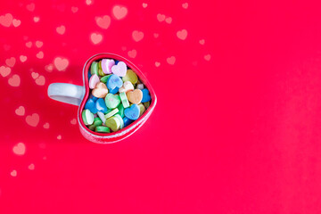 heart shaped cup filled with Valentines candies on a red background  with copy space, Valentinus's Day concept, Love