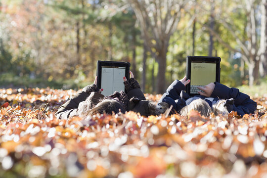 Girls using iPads in Autumn