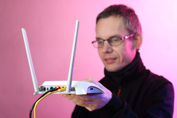 a person holding a white router with two antennas - obrazy, fototapety, plakaty