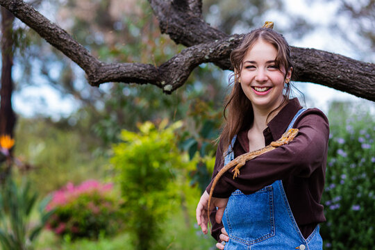 Copy Space Beside Happy Young Woman Standing Outside With Pet Bearded Dragon Lizards