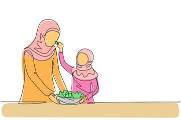 Single continuous line drawing Arabian mother feeds her daughter food and in front of her is bowl filled with salad. Cooking together in cozy kitchen. One line draw graphic design vector illustration
