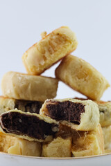 Bakpia Pathok. Yogyakarta traditional cake. steamed cakes. there are various kinds of flavors. original flavour, chocolate flavour, cheese flavour. served on a plate, against a plain white background.