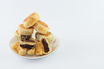 Bakpia Pathok. Yogyakarta traditional cake. steamed cakes. there are various kinds of flavors. original flavour, chocolate flavour, cheese flavour. served on a plate, against a plain white background.