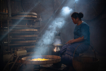 Silkworms are spun into threads by village women. the silk thread is wound into the tube