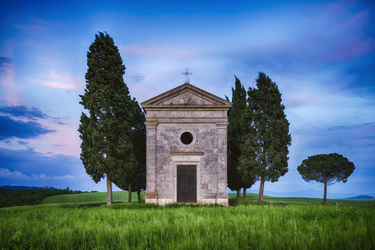 Chapel of Vitaleta with Cypress Trees at dusk after sunset. Chapel of Vitaleta, Val d&acute;Orcia, Siena Province, Tuscany, Italy.