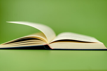 Thick book on green background, reading concept