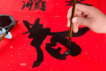 writing spring festival couplets to celebrate Chinese new year holidays.(the write word meaning fortune)
