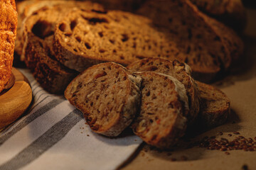 Bread, traditional sourdough bread, cut into slices on a rustic craftpaper background. The concept of traditional ways of baking yeast bread. Background for advertising