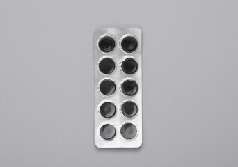 Blister of activated carbon on a gray background