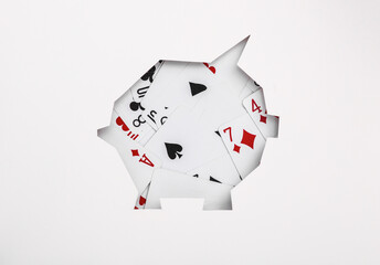 Piggy bank from cut paper with playing cards. Gambling concept