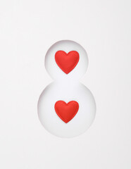 Number 8 cut out of paper hole with heart on white background. World Women's Day