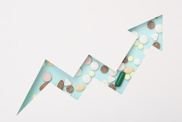 growth arrow cut out of paper hole with pills. Medicine concept