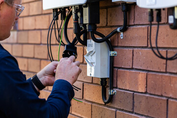 Electrician wiring up solar power system to house as part of the NSW Rebate Solar