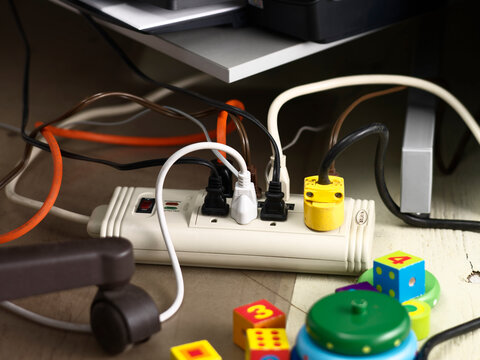 Cords Plugged into Power Bar and Children's Toys