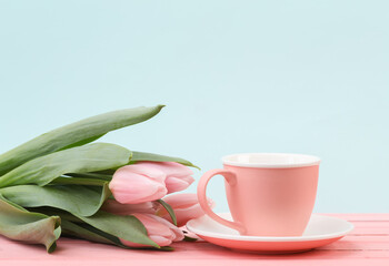 Obraz na płótnie Canvas Ceramic cup with tulips on a pastel background