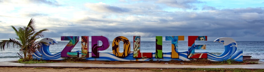 Panorama of a colorful city sign on the beach at sunrise, in Zipolite, Mexico